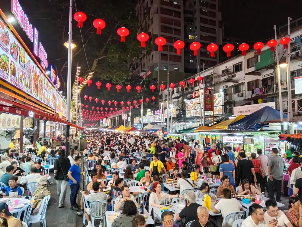 Red lanterns strung above the crowded night-market tables of Jalan Alor