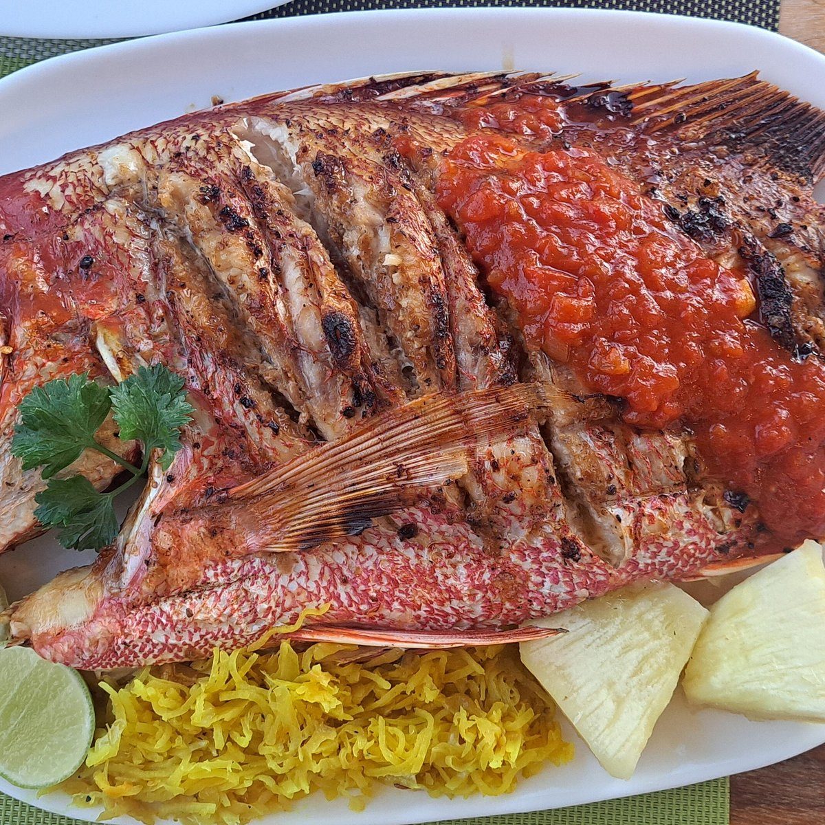 Whole grilled red snapper with tomato sauce and grated breadfruit at Perry's Grill