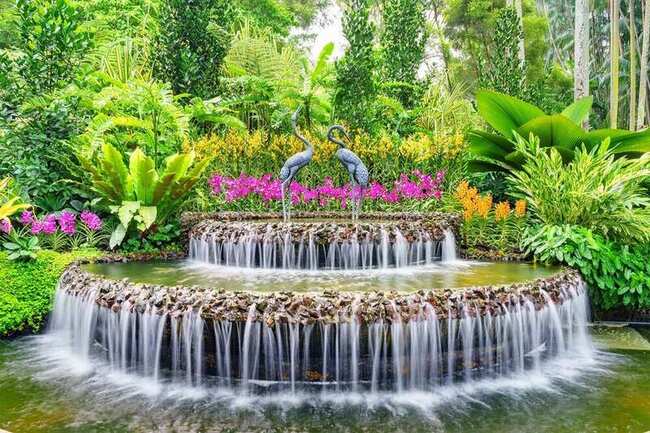 Waterfall and crane statues at the National Orchid Garden